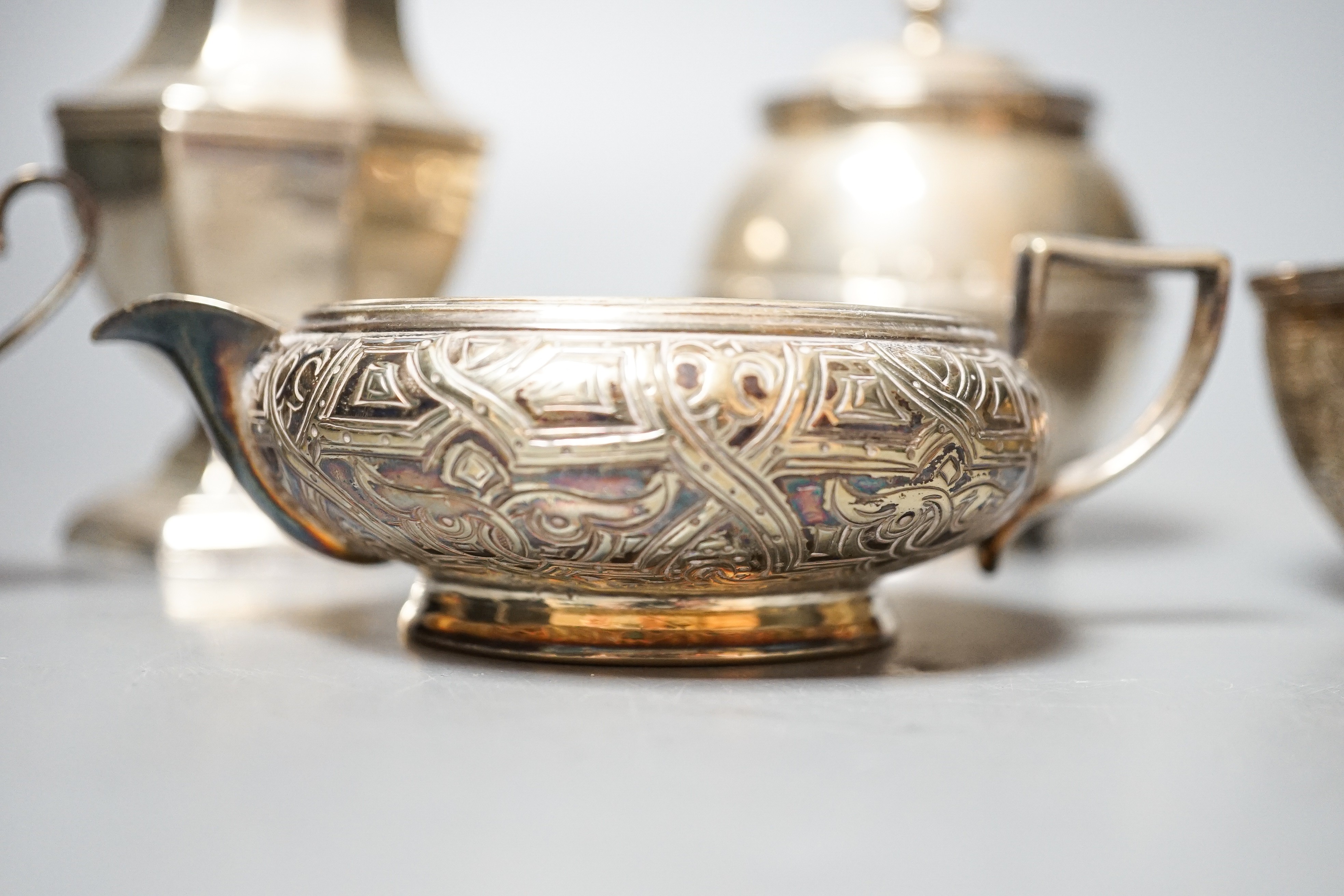 A George V silver sugar caster, 18cm, a silver globular pot with hinged cover, 9oz, a silver plated cream jug, sugar bowl, salt and spoon.